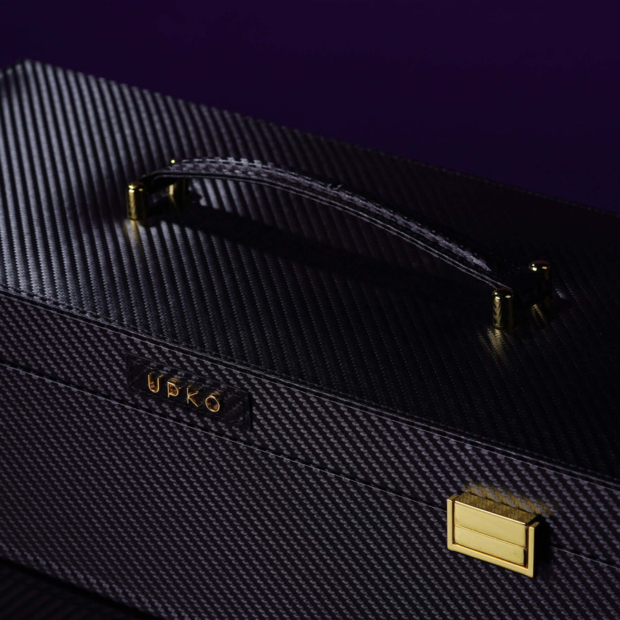 Luxury black bondage tools case with gold accents, featuring a textured surface and stylish handle.