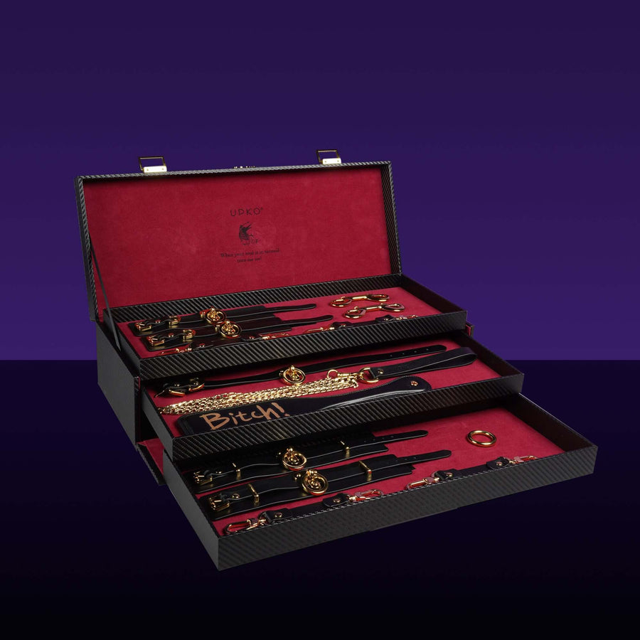 Luxury black bondage tools set in an elegant case featuring gold accents and a bold red interior, perfect for BDSM enthusiasts.